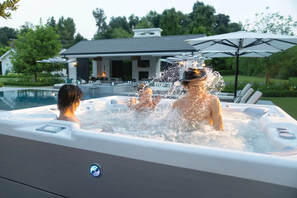 EINLADUNG: Hausmessen an allen 4 Standorten! 21.-23. Mai 2026 8 Kinder spielen im HotSpring Whirlpool im Garten – spritziges Spa-Erlebnis für Familien